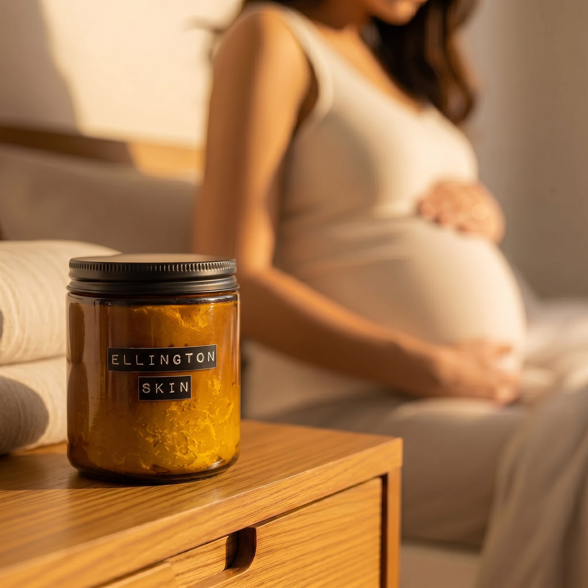 Ellington & Co. belly butter jar, expecting mother in warm light behind